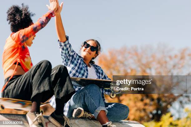 tjej skateboardåkare ger varandra high five på skate park - skatepark bildbanksfoton och bilder