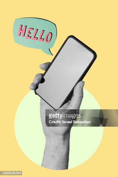 hand holding a smartphone on yellow background while a sign appears with "hello" words. - montage stock-fotos und bilder