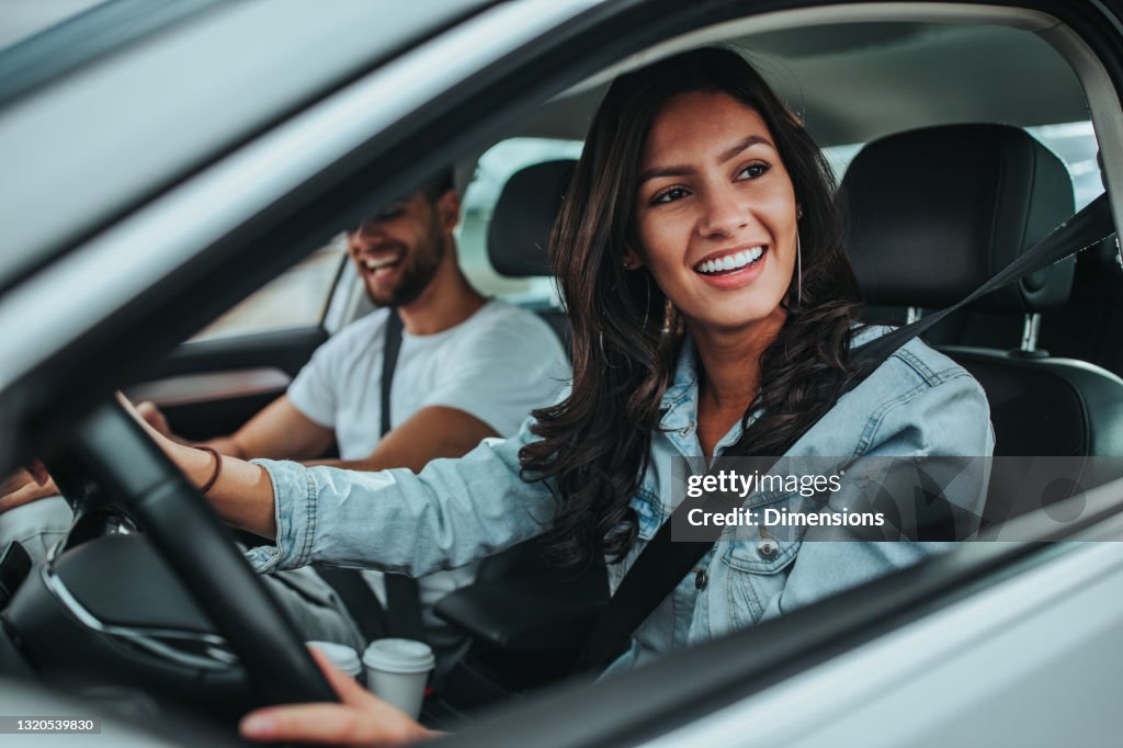 Jeune couple voyageant en voiture