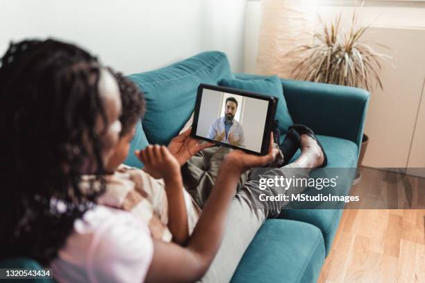 high angle photo of mother and son having call with family doctor - online doctor stock pictures, royalty-free photos & images