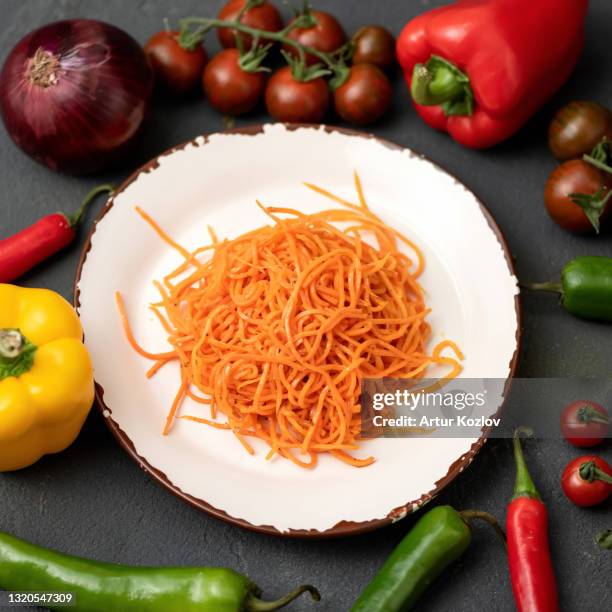 flat lay food. vitamin snack or appetizer. white clay plate with grated carrot salad on gray background with fresh whole vegetables on it. healthy food. vegan and vegetarian meal. soft focus - crunchy salad stock pictures, royalty-free photos & images