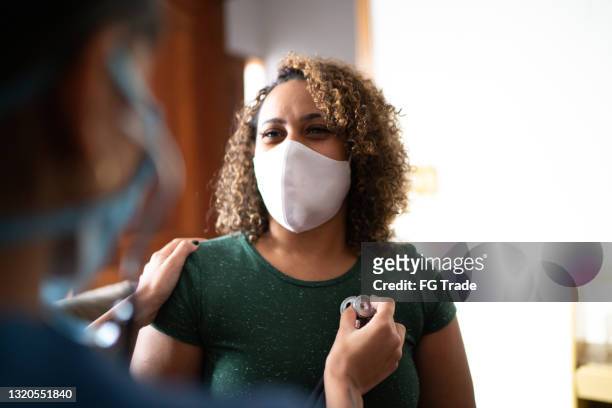 doctor listening to patient's heart at home during home visit - wearing protective face mask - human heart stock pictures, royalty-free photos & images