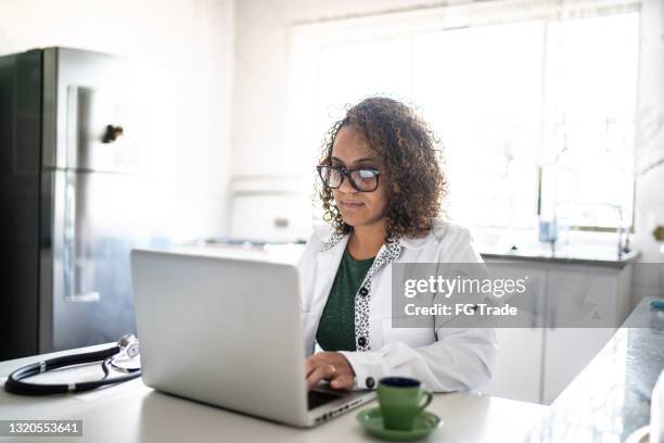 doctor working or doing a telemedicine call using laptop at home - concentration curl stock pictures, royalty-free photos & images