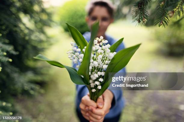 little boy giving flowers to his mother - bunches stock pictures, royalty-free photos & images