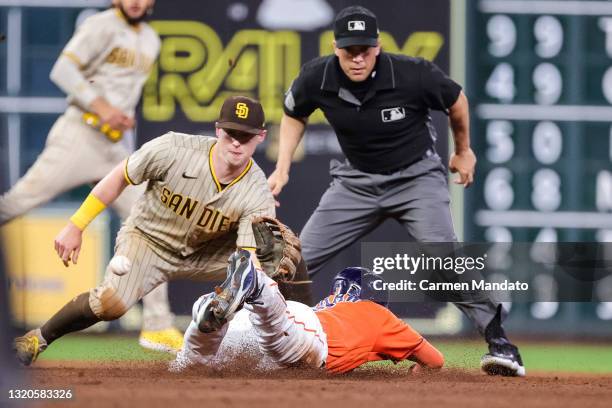 Myles Straw of the Houston Astros is caught stealing second by a tag from Jake Cronenworth of the San Diego Padres ahead of umpire Chris Segal during...