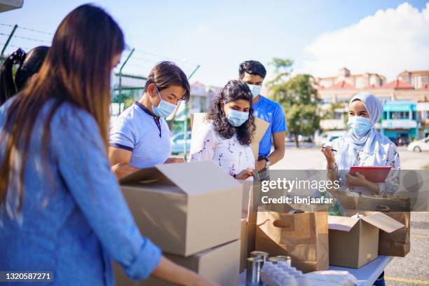 voluntarios de la campaña de alimentos trabajando juntos. - ayuda humanitaria fotografías e imágenes de stock