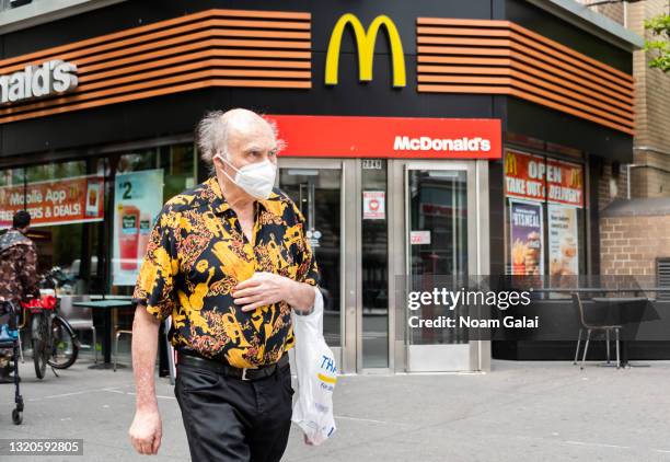 Person wears a face mask outside McDonald's on the Upper West Side on May 28, 2021 in New York City. On May 19, all pandemic restrictions, including...