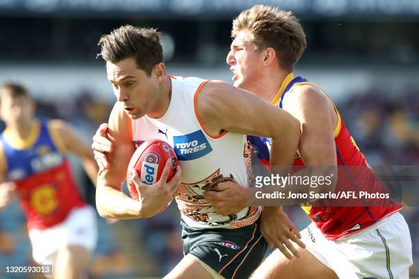 Josh Kelly of the Giants is tackled during the round 11 AFL match between the Brisbane Lions and the Greater Western Sydney Giants at The Gabba on...