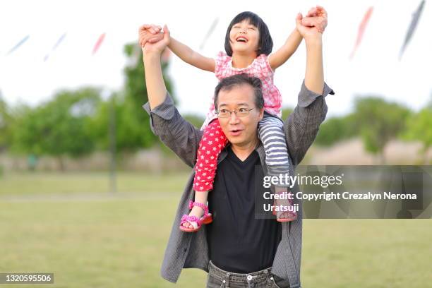 father and child with carp streamer on background smiling piggyback - 父の日　日本 ストックフォトと画像