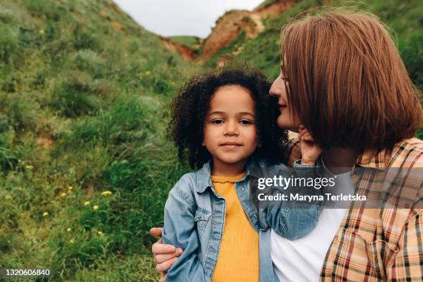 a white-skinned mother with a dark-skinned daughter is having fun. - babysitters club stock pictures, royalty-free photos & images