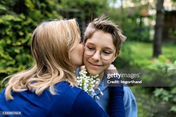 little boy giving flowers to his mother - lily of the valley stock pictures, royalty-free photos & images