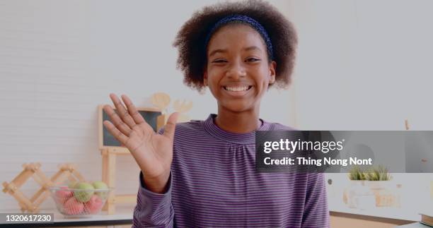 smiling black teen girl working on food blogger concept with fruits and vegetables in kitchen. - media portraits stock-fotos und bilder