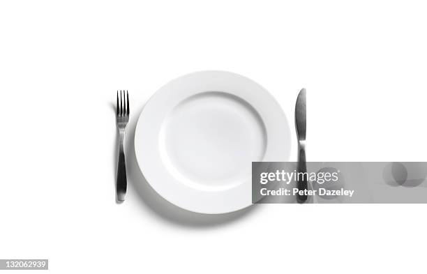 empty dinner plate on white background - ausgemergelt stock-fotos und bilder