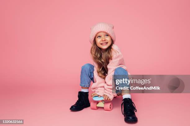 studio-porträt eines niedlichen mädchens mit skateboard - kids fashion stock-fotos und bilder