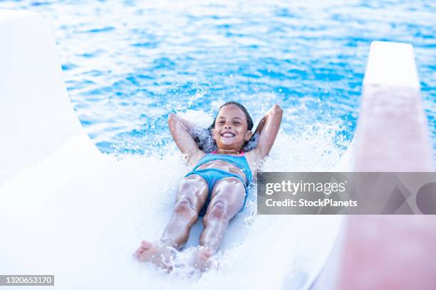 girl enjoy sliding to the pool - girls swimwear stock pictures, royalty-free photos & images