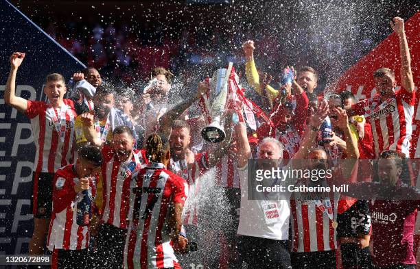 Pontus Jansson of Brentford lifts the Sky Bet Championship Play-off Final trophy in celebration with team mates after victory in the Sky Bet...