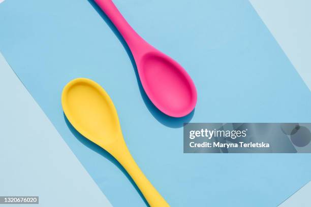 bright colored spoons on a colored background. - silicone foto e immagini stock