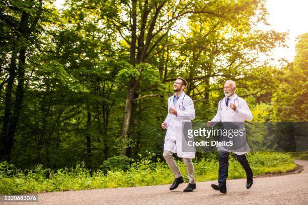 twee gelukkige artsen die in aard lopen. - happy runner stockfoto's en -beelden