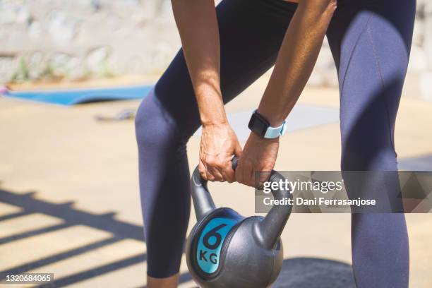 Young Attractive Woman Doing Kettle Bell Exercises Outside Fitness Woman Working Out At The Park High-Res Stock Photo