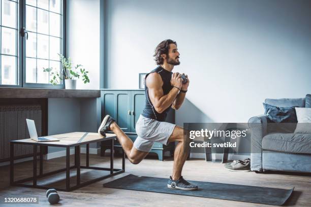 hombres jóvenes haciendo ejercicio en casa - entrenamiento deportivo fotografías e imágenes de stock