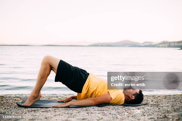 man practising bridge pose (setu bandha sarvangasana) - setu bandha sarvangasana stock pictures, royalty-free photos & images