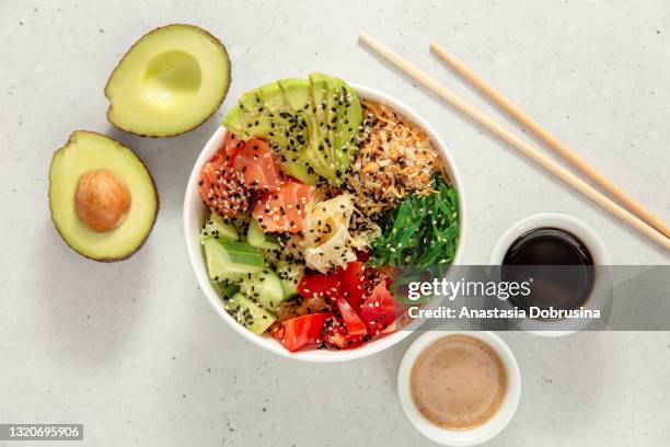 poke bowl with salmon, avocado, cucumber, tomato and seaweed. top view - salad bowl overhead stock pictures, royalty-free photos & images