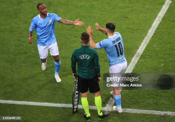 Raheem Sterling of Manchester City greets Sergio Aguero of Manchester City as Raheem Sterling is substituted off and Sergio Aguero is substituted on...
