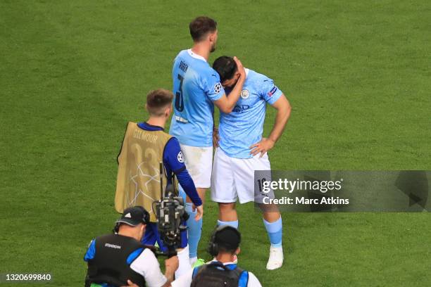 Ruben Dias of Manchester City consoles teammate Sergio Aguero of Manchester City who looks dejected following his team's defeat, and his last game...