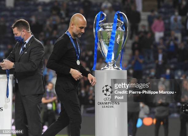 Pep Guardiola, Manager of Manchester City looks dejected as he walks past the Champions League Trophy after the UEFA Champions League Final between...