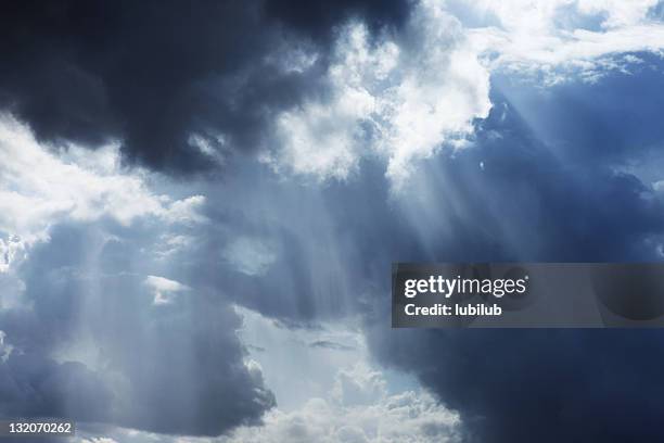 storm cloudscape with sunbeams on a dramatic sky - dramatic sky stockfoto's en -beelden