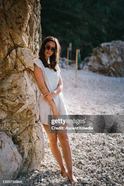 de jonge vrouw ontspant op mediterraan strand - minijurk stockfoto's en -beelden