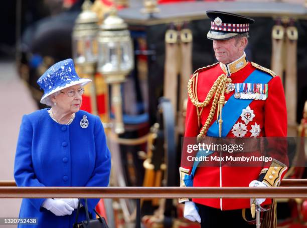 Queen Elizabeth II and Prince Edward, Duke of Kent stand on a dais outside Buckingham Palace during the annual Trooping the Colour Ceremony on June...