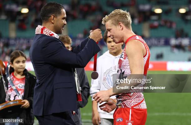 Former Swans player Michael O'Loughlin presents Isaac Heeney of the Swans with the Goodes-O'Loughlin medal after the round 11 AFL match between the...
