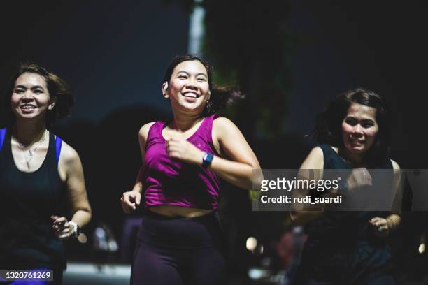 night running in gelora karno jakarta - asian woman smiling sunrise stock pictures, royalty-free photos & images