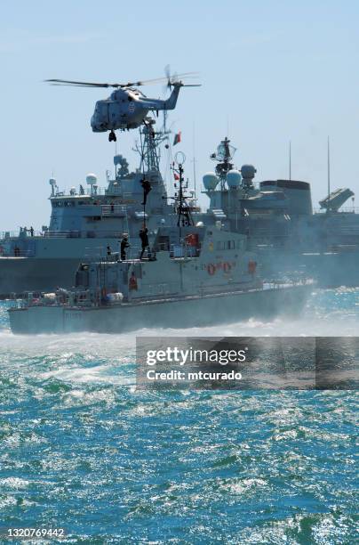 fast-roping at sea - super lynx mk.95 helicopter dropping marines on patrol vessel p1155 nrp centauro, setubal, portugal - military rescue stock pictures, royalty-free photos & images