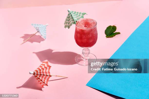 summer watermelon drink on pink background and summer accessories - cocktail umbrella stock-fotos und bilder