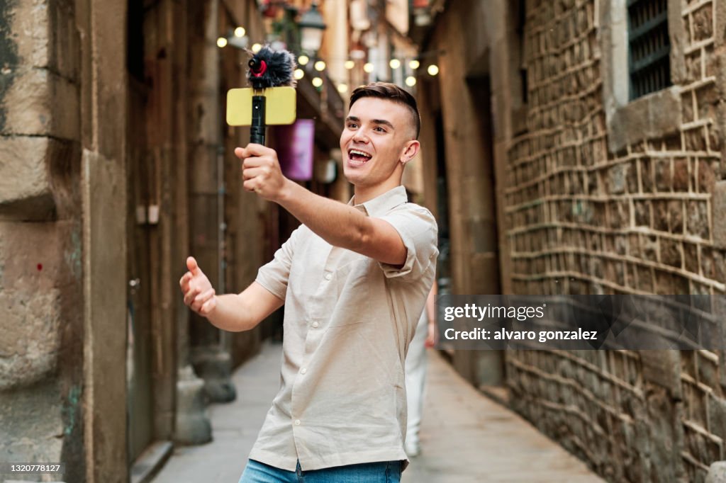 Young influencer and z generation model streaming with a smartphone and microphone