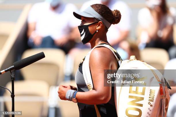 Naomi Osaka of Japan talks as she is interviewed on court after winning her First Round match against Patricia Maria Tig of Romania during Day One of...