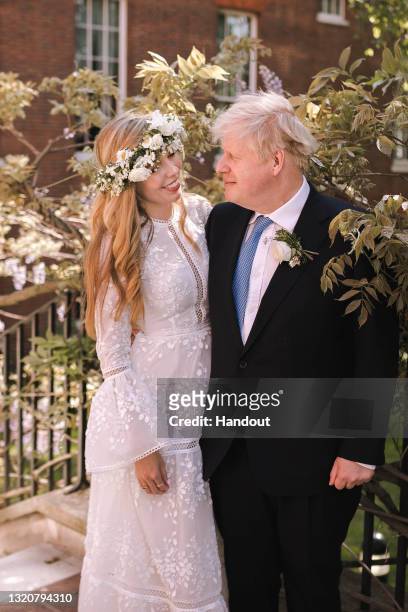 In this handout image released by 10 Downing Street, Prime Minister Boris Johnson poses with his wife Carrie Johnson in the garden of 10 Downing...