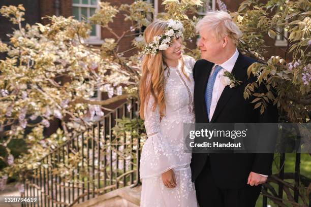 In this handout image released by 10 Downing Street, Prime Minister Boris Johnson poses with his wife Carrie Johnson in the garden of 10 Downing...