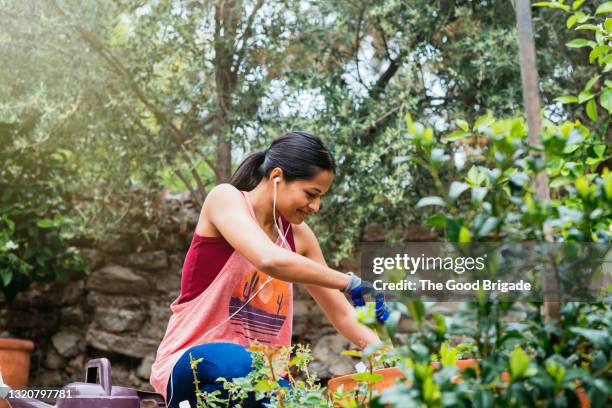 cheerful woman gardening in backyard - jardinería fotografías e imágenes de stock