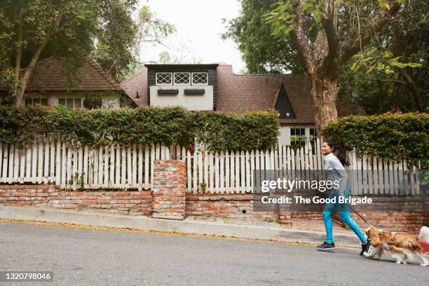 woman jogging in street with dog - colina acima imagens e fotografias de stock