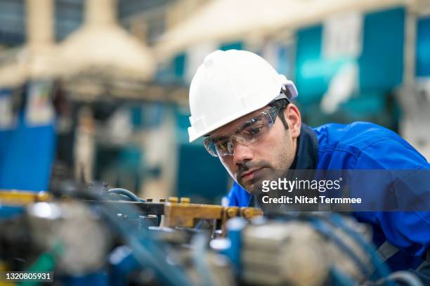 accuracy and quality control in assembly welding processes.  design engineer examining and fitting of assembly welding jig at engineering part production line in automobile manufacturing. - auto manufacturing stockfoto's en -beelden