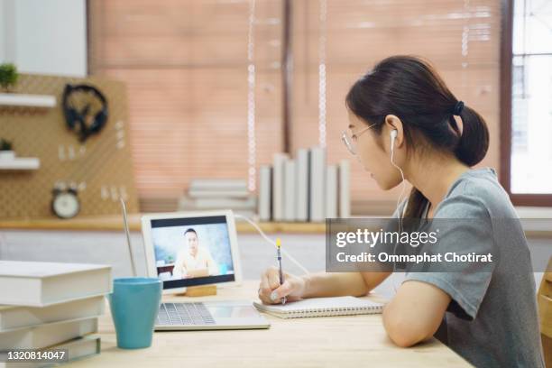 teenage student girl sit at kitchen table doing e-learning at home - chinese tutor study stock pictures, royalty-free photos & images