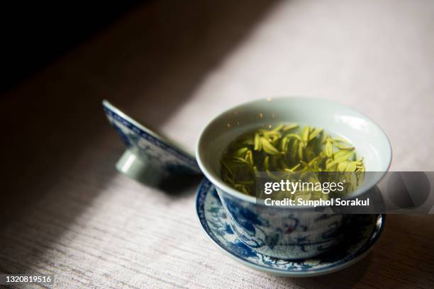 traditional chinese tea cup with green tea - green tea leaves stockfoto's en -beelden