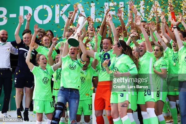 Alexandra Popp and Almuth Schult of VfL Wolfsburg lift the DFB Cup as their team mates celebrate victory in the Women's DFB Cup Final match between...