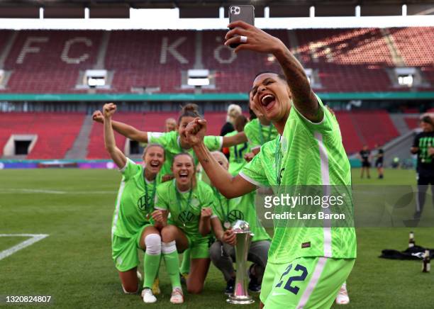Players of VfL Wolfsburg celebrate with the DFB Cup as Shanice van de Sanden of VfL Wolfsburg takes a photo following victory in the Women's DFB Cup...