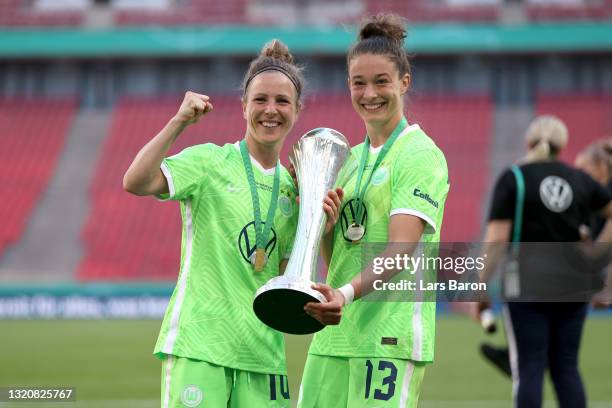 Svenja Huth and Felicitas Rauch of VfL Wolfsburg hold the DFB Cup following victory in the Women's DFB Cup Final match between Eintracht Frankfurt...