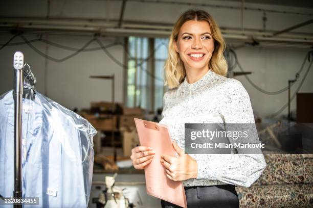 eine junge frau arbeitet in einem lager hausdert in der modebranche. - stickerei stock-fotos und bilder