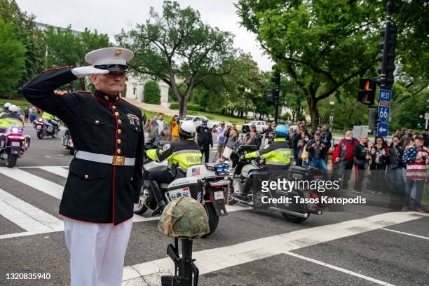 Staff Sgt. Tim Chambers salutes as motorcyclists participate in the "Rolling to Remember" motorcycle rally as they ride past the Lincoln Memorial on...